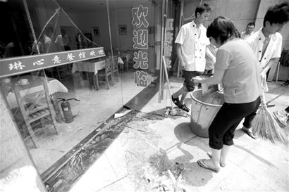 楚天金报讯 图为：餐馆工作人员收拾门前的碎玻璃 记者邹斌摄