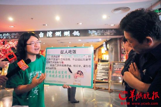 5月6日下午,乙肝维权人士雷闯举牌征人吃饭 羊城晚报记者 蔡弘 摄