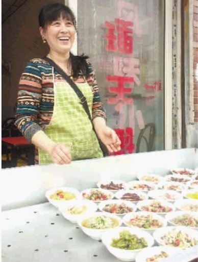 长沙市河西天马学生公寓附近，浏阳林家蒸菜馆的老板刘艳红站在店门口迎接客人。