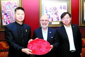 中国烹饪协会副会长许云飞（右）、阿五品牌创始人樊胜武（左）向土耳其餐饮业协会创始人之一阿卜杜拉（中）赠送礼品