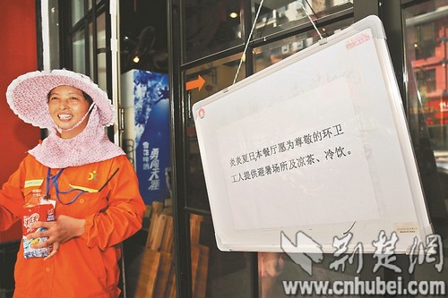 图为：昨日下午，环卫工刘燕萍在“妙厨”餐馆休息后离开