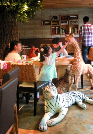 昨天下午五时许，在Zoo Cafe，一位小朋友好奇地摸着长颈鹿模型。