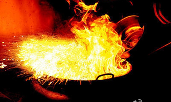 餐馆油锅起火，老板拿水浇险酿大祸。