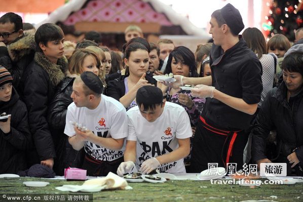 2011年12月12日，俄罗斯叶卡特琳堡，游客在MEGA贸易中心品尝由600名厨师制作的2.5km长饭卷。活动组织者申请了吉尼斯纪录并获得通过。