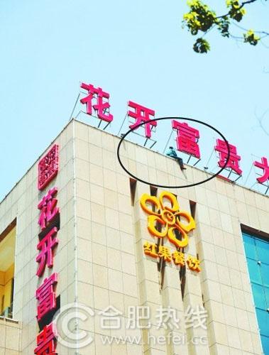 女子爬上高高的楼顶要自杀