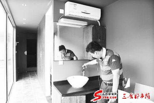 “香箱乡”祈福村吉田“村长”检查集装箱酒店设施。